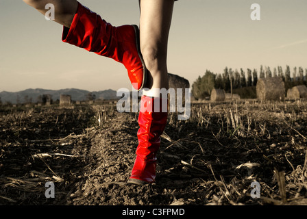 Mädchen im roten Wellington Stiefel im Feld Stockfoto