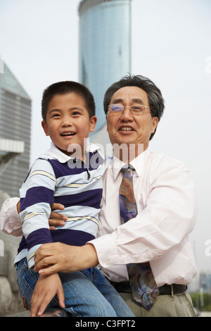 Chinesischen Großvater und Enkel sitzen zusammen im freien Stockfoto