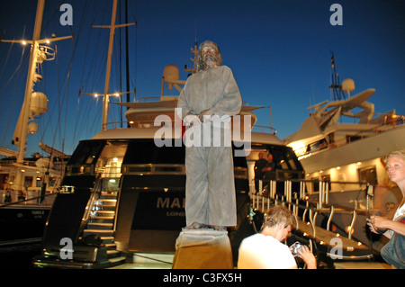 Menschen Sie handeln, wie eine Statue vor Luxus im Hafen von St. Tropez, Südfrankreich Boote. Stockfoto