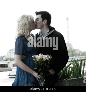 Kaukasische Frau holding Bouquet und Küsse Freund in der Nähe von Eiffelturm Stockfoto