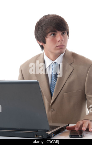 Ein Portrait eines Teenagers in Business-Anzug mit Computer, Handy. Stockfoto