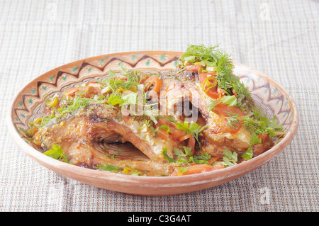 Traditionelle rumänische Speisen aus gegrillten Fisch auf Salz und bedeckt mit pikanter sauce Stockfoto