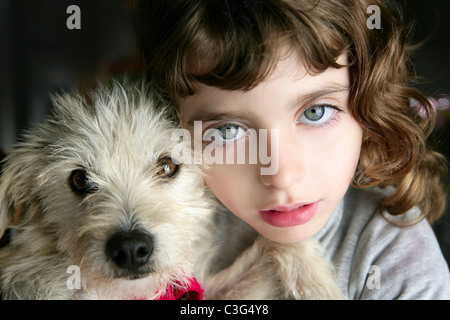 Hund Welpe und Mädchen umarmen Porträt Closeup blaue Augen weißen haarigen kleinen Doggy Stockfoto