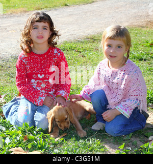 zwei kleine Mädchen Schwester Freunde golden Retriever Welpe Hund Outdoor-Park Stockfoto