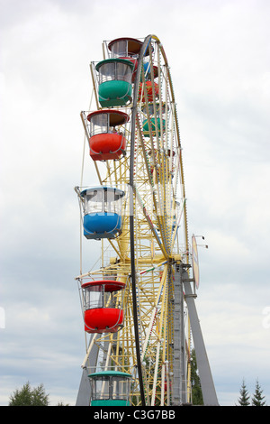 Riesenrad eine Attraktion mit bunten Ständen gegen den Himmel Stockfoto