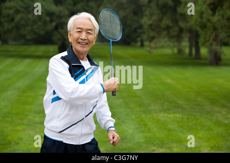 Senior Woman spielen Badminton in einem Park Stockfoto