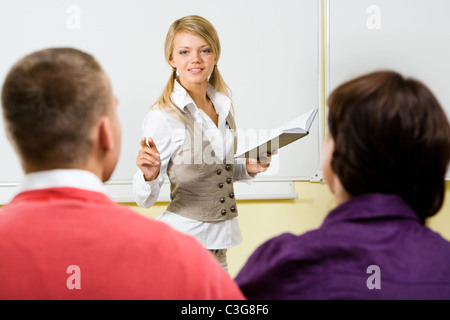 Bild von kluge Lehrer mit Buch in der hand etwas erklärt den Schülern im Unterricht Stockfoto