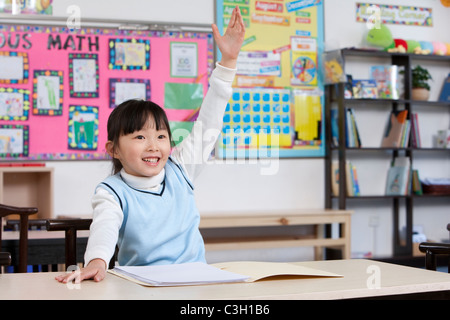 Junger Student hob ihre Hand im Klassenzimmer Stockfoto