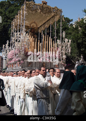 Costaleros tragen einen religiösen Float (bekannt als ein Trono) an den Prozessionen der Semana Santa in Málaga, April 2011 Stockfoto