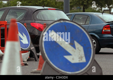 Fahrzeugen, Wegweiser und Zapfen in Baustellen in London, England Stockfoto