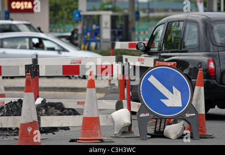 Fahrzeugen, Wegweiser und Zapfen in Baustellen in London, England Stockfoto