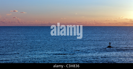 Sonnenuntergang über dem Pazifik Schwimmer steht auf einem Felsen. Osterinsel. Stockfoto