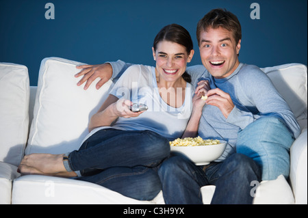 Paar vor dem Fernseher auf Sofa und Essen popcorn Stockfoto