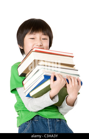 Jungen tragen einen großen Stapel Bücher Stockfoto