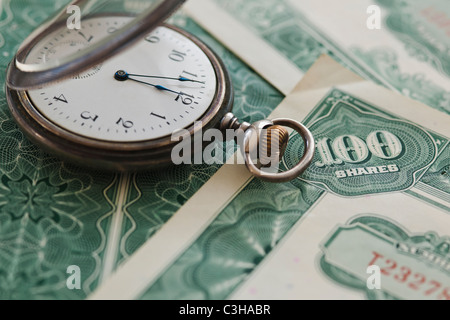Nahaufnahme der Taschenuhr und Aktien Stockfoto