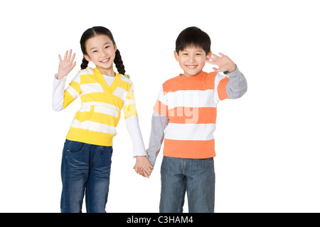 Zwei Freunde winken beim Händchenhalten Stockfoto