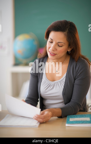Lehrerin am Schreibtisch im Klassenzimmer Stockfoto