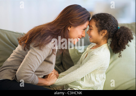 Mutter mit Tochter (6-7) auf Sofa spielen Stockfoto