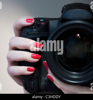 Nahaufnahme von Frauenhand mit rotem Nagellack, die Kamera zu halten Stockfoto