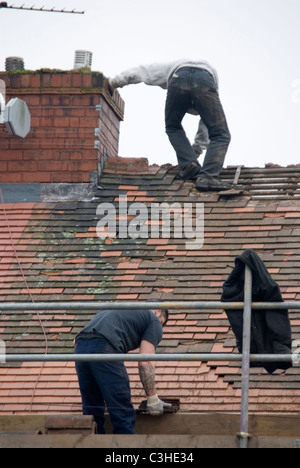 Mann auf dem Dach des Hauses hält Schornstein Abstreifen der alte Fliesen, Re Überdachung Wohn-Hause Ontop Bedachungen, Sheffield, England Stockfoto