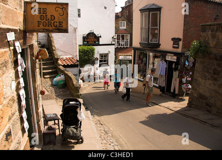 Touristen zu Fuß auf der Hauptstraße in Fischerdorf von Robin Hoods Bay, North Yorkshire, England, UK Stockfoto