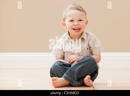 Porträt des jungen (2-3) sitzt im Schneidersitz Stockfoto