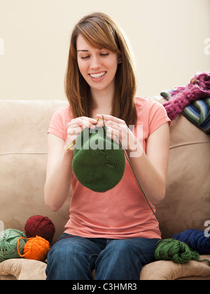 Junge Frau stricken Wollmütze Stockfoto