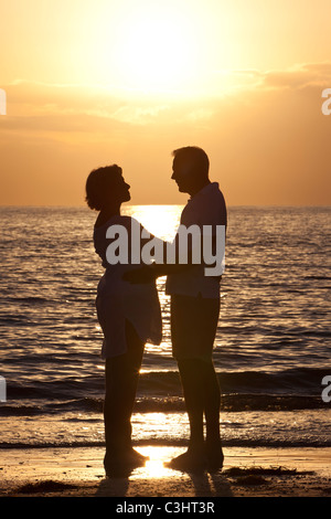 Ältere Mann und Frau paar umarmt zusammen bei Sonnenuntergang an einem wunderschönen tropischen Strand Stockfoto