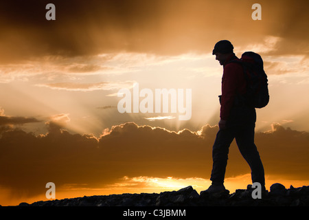 Jacobs Leitern durch die untergehende Sonne und eine Gehhilfe silhouettiert, Lake District, Großbritannien. Stockfoto