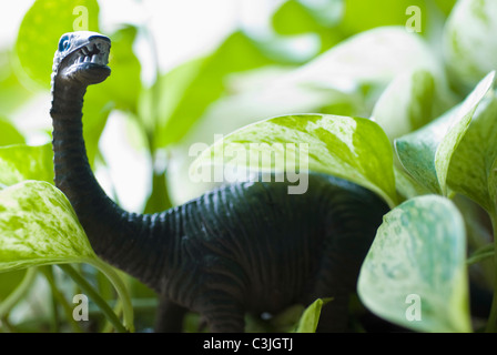 Figur der Dinosaurier unter den Blättern Stockfoto