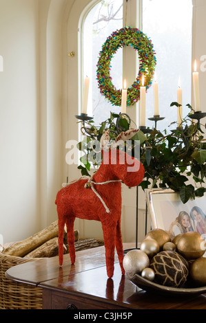 Rentier Weihnachtsdekoration auf Tischplatte mit Kugeln und festliche Kerze Anordnung gewebt Stockfoto