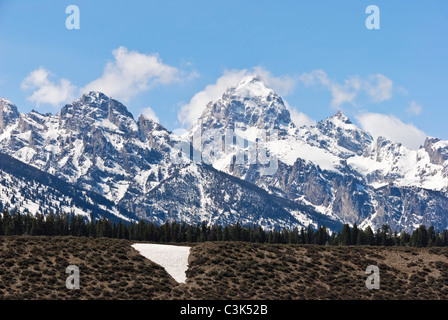 Wispy, weißen Wolken tanzen auf schneebedeckten Gipfeln in Teton in Wyoming des Grand Teton National Park. Stockfoto