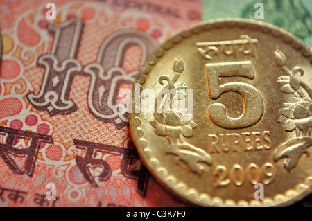 Indische Währung, eine Münze von Rs. 5 und im Hintergrund ein Hinweis von Rs. 10 Stockfoto