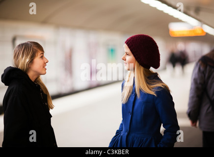 Teenager (14-15) am Bahnsteig sprechen Stockfoto