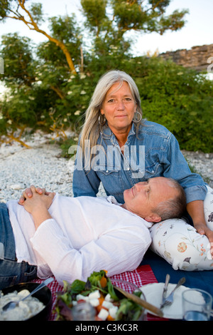 Älteres Paar mit Picknick am Strand Stockfoto