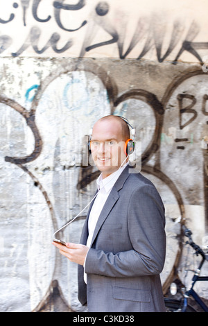 Mann auf der Straße hören mp3-Player, Lächeln Stockfoto