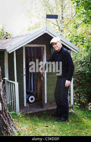 Ältere Mann von Schuppen im Garten Stockfoto
