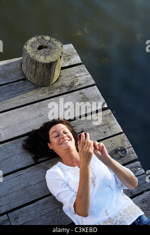 Eine Frau auf einem Steg am See, Schweden. Stockfoto