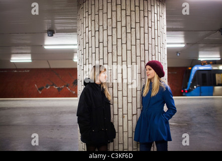 Teenager (14-15) am Bahnsteig sprechen Stockfoto