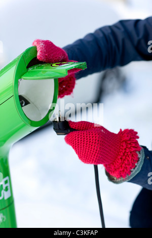 Junge Frau Ladestation Elektroauto Stockfoto