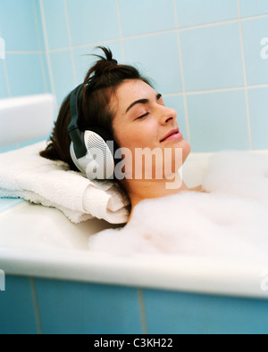 Mitte Erwachsene Frau in Badewanne, entspannende Musik hören Stockfoto