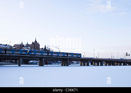 Personenzug auf der Durchreise Brücke über den zugefrorenen See Stockfoto