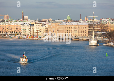 Schlepper und Segelschiff am Fluss in der Stadt Stockfoto