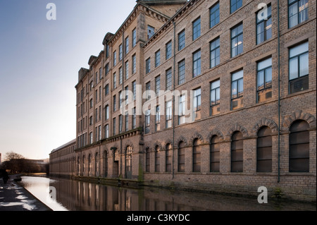 Salts Mill (große, historische, viktorianische Fabrik oder Textilmühle Gebäude am Kanal) bei Sonnenaufgang - Banken von Leeds Liverpool Canal, Saltaire, England, Großbritannien. Stockfoto