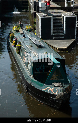 Blumenbedeckten schmale Boot navigiert aus Camden Lock (Hampstead Road Lock), Richtung Hawley-Sperre auf der Regent Canal Stockfoto