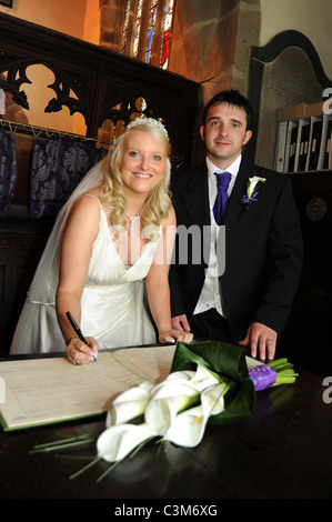 Ein paar Zeichen die Ehe während der Zeremonie bei ihrer Hochzeit registriert Stockfoto