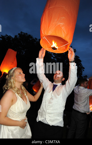 Ein frisch verheiratetes Paar starten eine chinesische Laterne auf der Hochzeit Partei Stockfoto