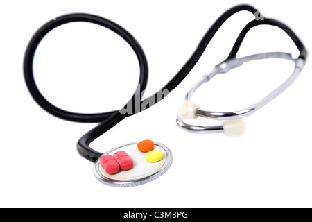 medizinisches Konzept mit bunten Pillen und Stethoskop auf weiß Stockfoto