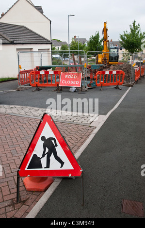 Männer in Arbeit-Schild in der Nähe von einem Abschnitt des städtischen Straße geschlossen für Ausgrabungen. Die Straße ist in einem Wohngebiet Stockfoto