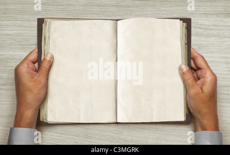 männliche Hände und geöffnete Vintage Buch über Tisch Stockfoto